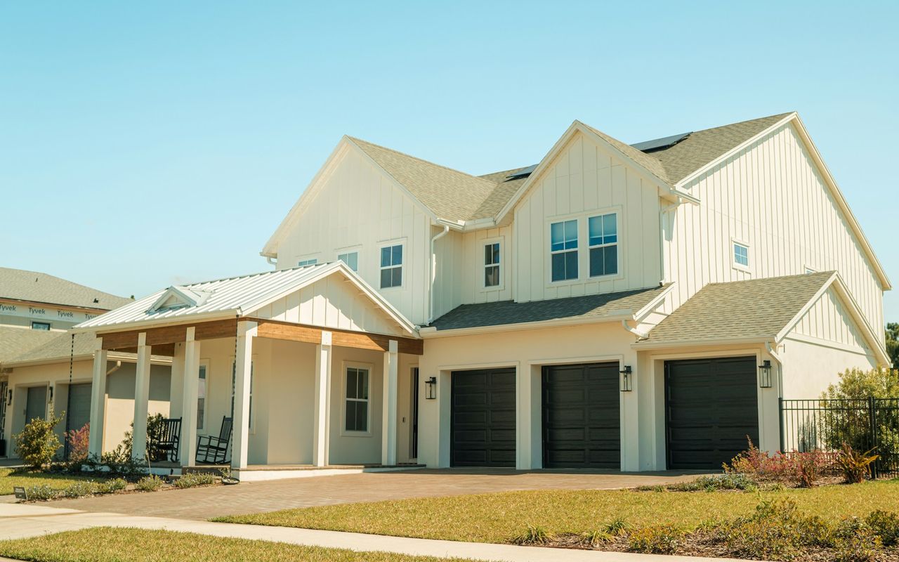 A brand-new two-story white farmhouse-style home with a front porch in Lake Nona, Florida