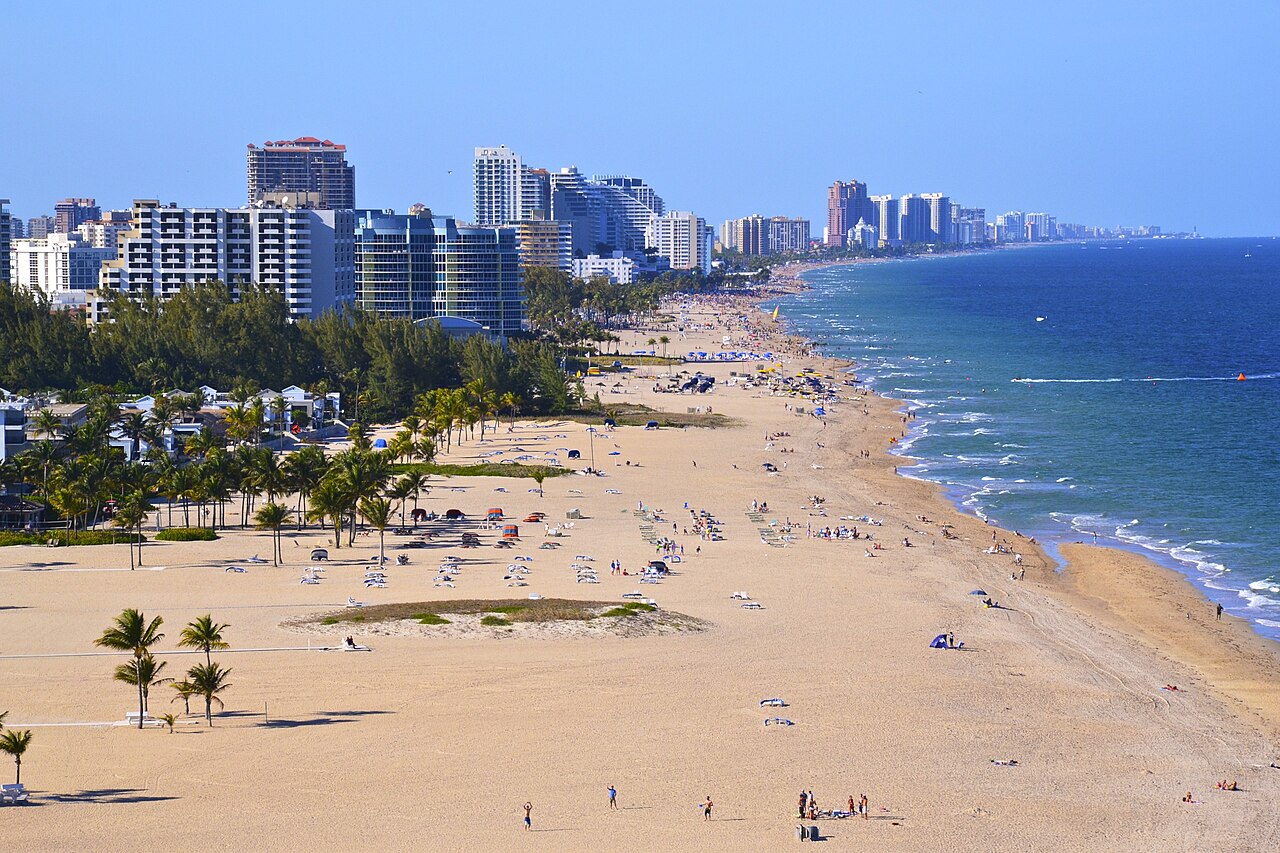 A wide sandy beach lined with palms and high-rises in Fort Lauderdale