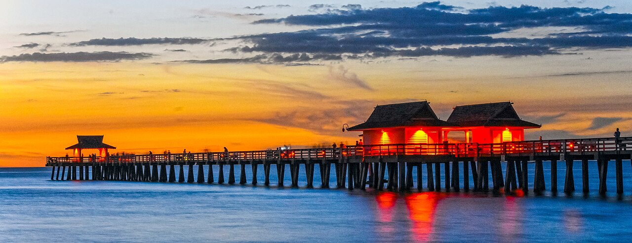The Naples Pier glowing at sunset over the Gulf